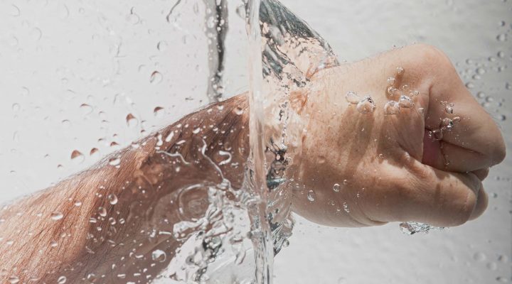 Image of a fist punching through water (horizontal)
